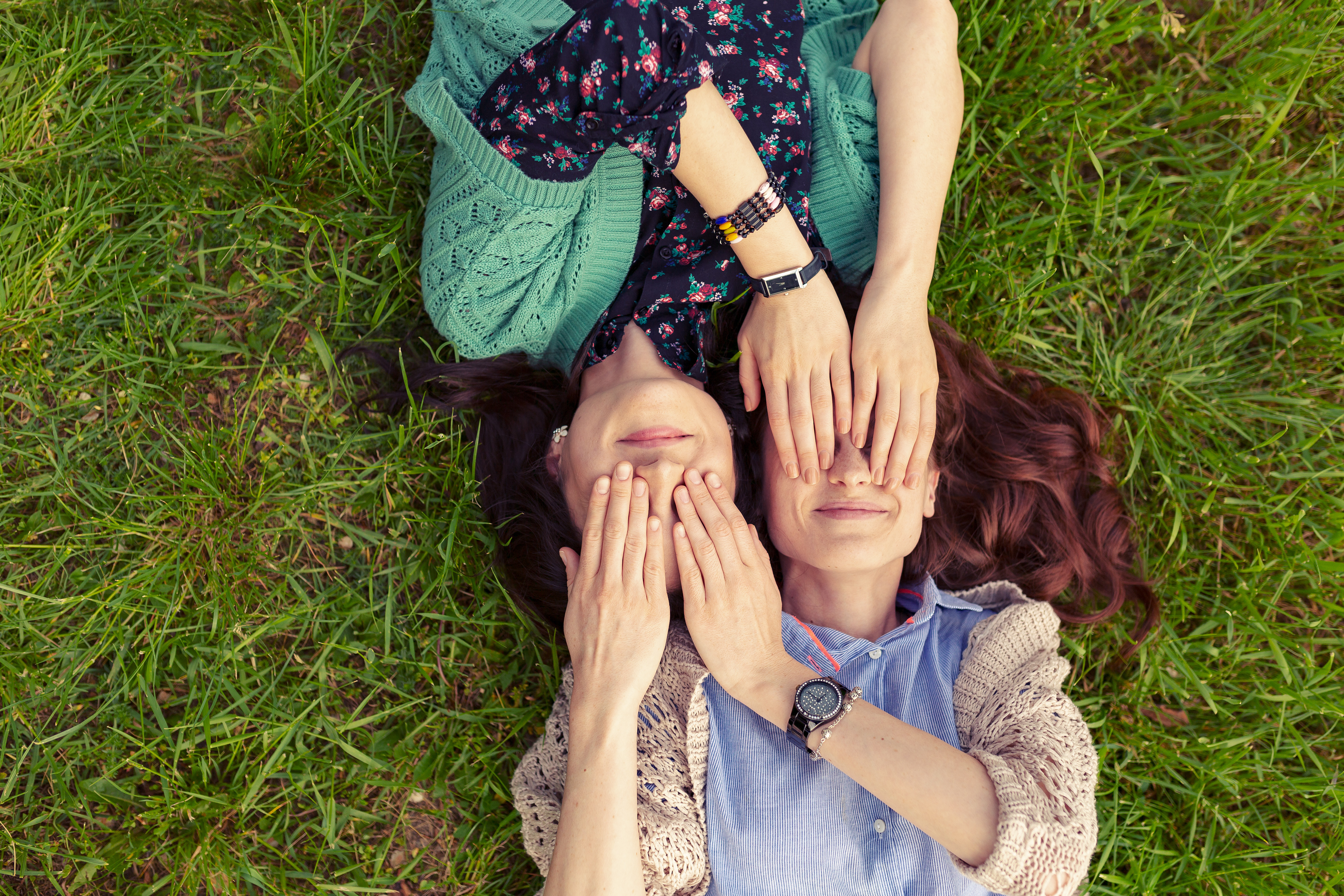 Top view of smiling friends lying on grass